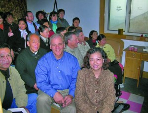 Drake Snodgrass (center in blue) with Chinese business ethics students. Above right: a workbook created by Snodgrass and other ethics instructors.