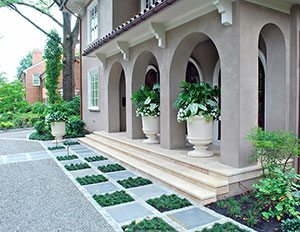 Blooms where they’re planted. The custom cast planters overflowing with plants can be viewed from the street and the living room. A random paving pattern with mondo grass inlays buffers the parking area.
