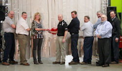 Cutting the ribbon, from left, are Line Supervisor Chris Gruss, Tree Care Products Sales Manager Casey Gross, VP of Finance Debbie Lehmann, Product Manager Jason Showers, Welder Mike Jolman, Engineer Craig Swan, Engineering Manager Larry Voelker, and President Jim Shoemaker Jr. Standing in front of Voelker and Shoemarker is Jim Bardos, manager and operation engineer.