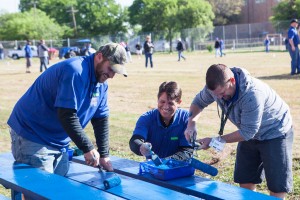 As part of its second annual PRIDE Project, Ewing repainted bleachers, among other tasks, at St. Philip the Apostle Catholic School. Photo: Ewing