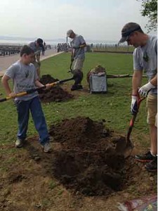 Taylor Tauscher, 9, and Landscape Management Publisher Bill Roddy (right) dig a hole for a 3-in. diameter London Plane tree planting. In the background, Rick Murphy (left) and Dave Boulter of Real Green Sytems do the same.