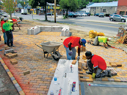 Local residents install pavers at Project Scion: The Orchard. Photo: Zaretsky & Associates