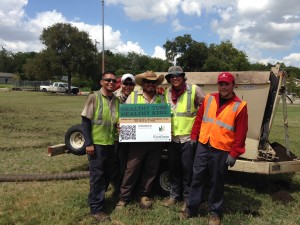 Some of the more than two dozen volunteers for the “Healthy Turf. Healthy Kids.” project take a break from renovating West End Park in San Antonio.