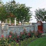The custom stone wall provides an aesthetic separation and privacy from the pool terrace to the driveway.