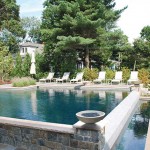 Custom concrete bowls, placed on the stone columns at the end of the negative edge, frame the views of the pool and produce the tranquil sound of falling water.