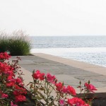 This low perspective shot details the raised terrace with its limestone accents. Oriental Fountain Grass and Knock Out Roses offer plenty of summer time color and texture.