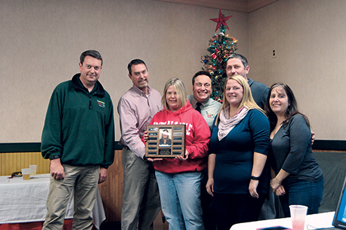 Blades of Green managers award team member Gidget Trott with one of the company’s “Fred of the Year” awards.