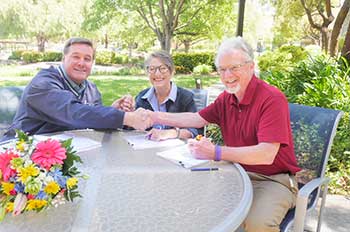 From left to right: Jim Ingram, Nelda Matheny and Jim Clark shaking hands