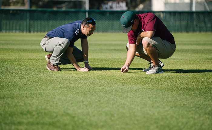 Gil Del Rosario (left) discusses turf management with a sports turf manager. (Photo: Corteva Agriscience™, Agriculture Division of Dow DuPont)