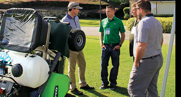 Turfco President George Kinkead (left) talks to the Spring Touch Lawn & Pest Control team about the finer details of the T3100 spreader-sprayer. (Photo: Seth Jones)