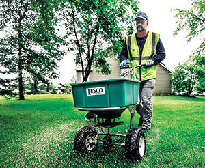 Crew member operating a spreader (Photo: SiteOne Landscape Supply)