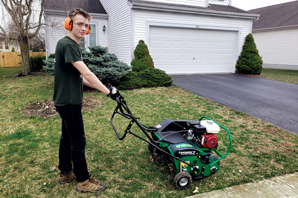 Grant Weckerly, a scout with Troop 318 in Delaware, Ohio, stands with a Ryan Lawnaire V aerator loaned by Hayward Distributing Co. Photo: Craig Myers