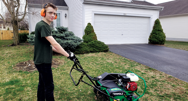 Grant Weckerly, a scout with Troop 318 in Delaware, Ohio, stands with a Ryan Lawnaire V aerator loaned by Hayward Distributing Co. Photo: Craig Myers