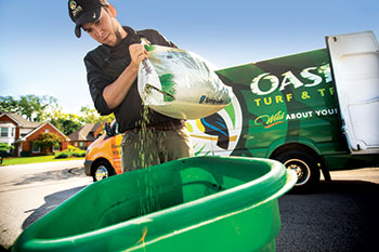Man using lawn care product (Photo: Oasis Turf & Tree)
