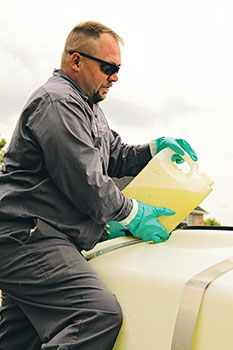 Man pouring chemicals (Photo: Dow Agrisciences)