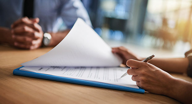 Person signing papers (Photo: iStock.com/peopleimages)