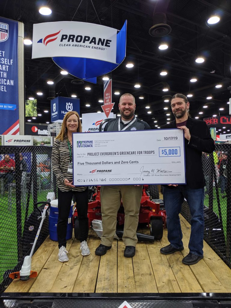 Jeremy Wishart presents a check for $5,000 to Project Evergreen's executive director, Cindy Cole, and Joe Shooner, president of Focal Point Communications. (Photo: LM Staff)