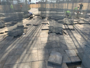 Crews had to hand cut pavers around art structure columns and LED lighting was cored into the paver to keep a level plane. (Photo: Urban Habitat)