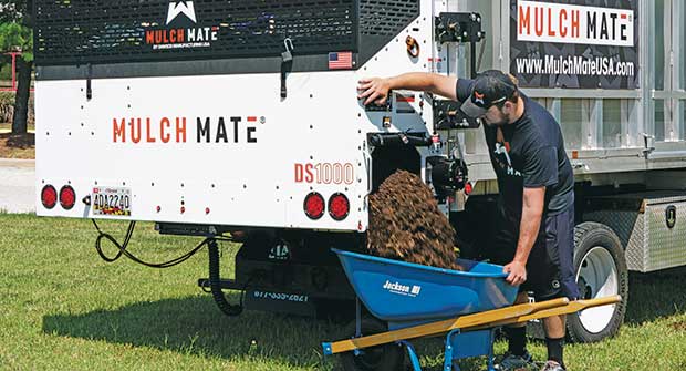 Person filling wheelbarrow using Mulch Mate (Photo: Mulch Mate)