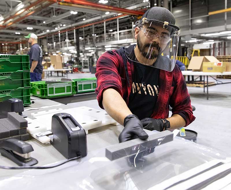 an assembler at John Deere Seeding Moline, assembles protective face shields for health-care workers.