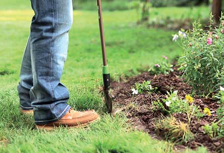 Person digging to install edging (Photo: Coyote Landscape Products)