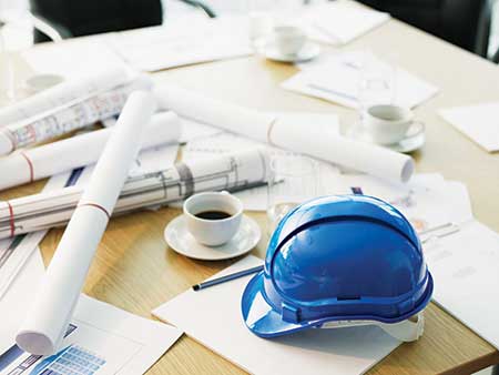 Hardhat and construction plans (Photo: Chris Ryan/OJO Images/Getty Images)