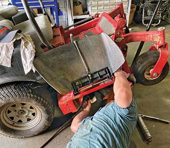 Person servicing mower (Photo: Froio Lawn & Landscape)