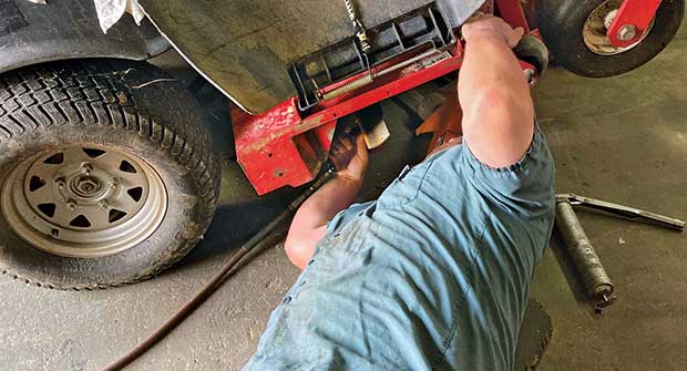 Person servicing mower (Photo: Froio Lawn & Landscape)