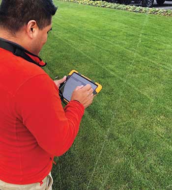 Crew member using weather-based irrigation. (Photo: Pacific Landscape Management)