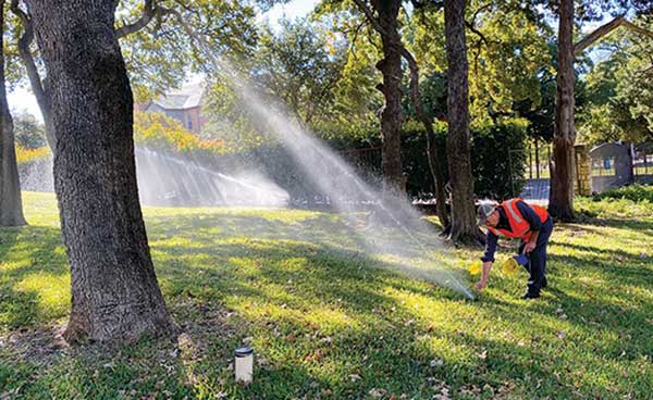 Crew member adjusting irrigation head (Photo: Earthworks)