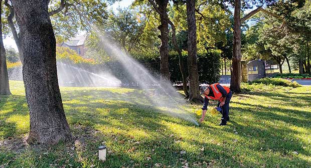 Crew member adjusting irrigation head (Photo: Earthworks)
