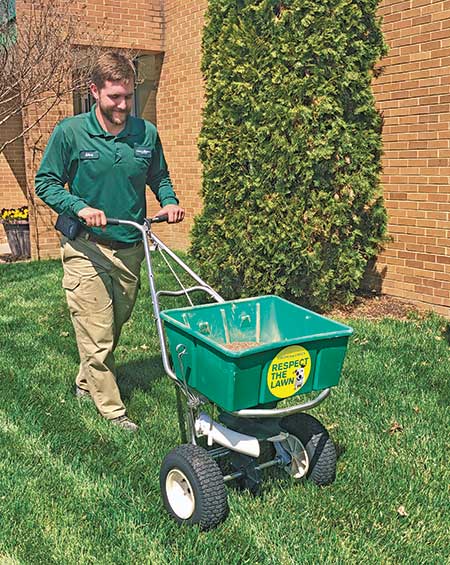Crew member spreading fertilizer (Photo: Virginia Green Lawn Care)
