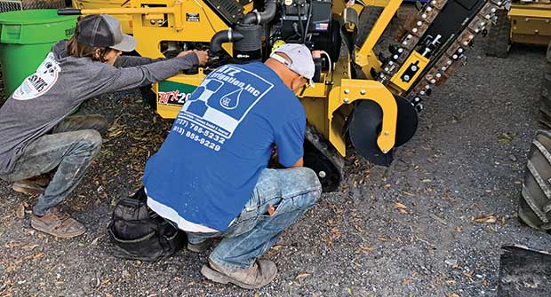 People servicing a trencher (Photo: Tom Zullo/ATZ Irrigation)