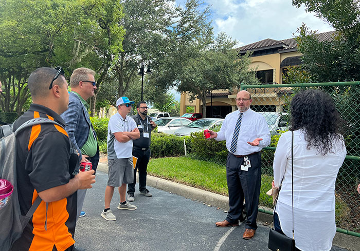 Sean Clifford (center), director of learning with Massey Services, leads Elevate attendees on tour of the company's headquarters in Orlando, Fla. (Photo: LM Staff)