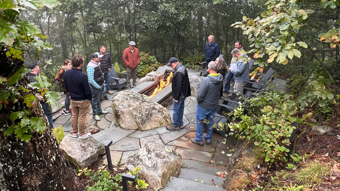 Peer Group members surround a fire pit on a nook on the property. (Photo: Jeffrey Scott)