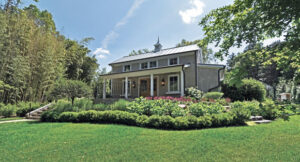 McHale planted green velvet boxwood, hydrangea, astilbe, hosta and amsonia to compliment the main entrance to the shed. To the far right, a masonry set of steps leads up to the porch while on the right, rustic boulder steppers also provide access. (Photo: McHale Landscape Design)