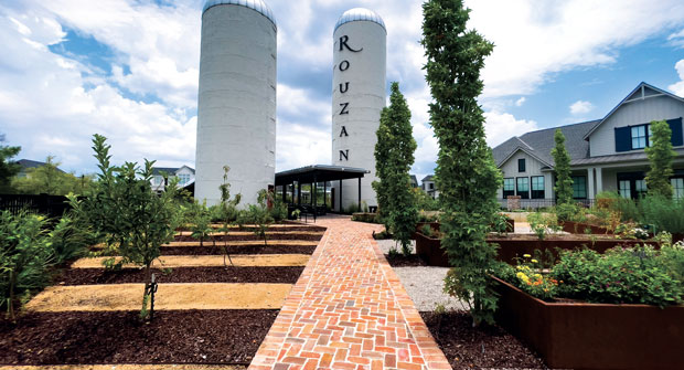 The main walkway is flanked by fruit trees on the left and steel flower planter boxes on the right. (Photo: EdgeForm Landscape Management)