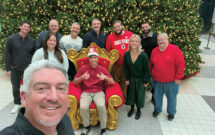 Happy holidays!: Most of the Landscape Management team got together in front of a giant Christmas tree for our holiday card. Seth is in front, with (left to right) Jake Goodman, Sydney Fischer, Scott Hollister, Bill Roddy, Craig MacGregor, Nathan Mader (seated), Rob DiFranco, Payton Szymczak, Nader Hassen and Pete Seltzer. (Photo: LM staff)