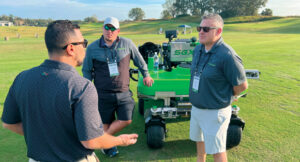 LM Growth Summit attendee Noe Loarca (left) talks with Caleb Myers and Matt Smith from Steel Green in the outdoor demo area. (Photo: LM staff)
