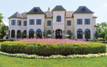 The sizeable circular bed in the middle of the circular drive with Russian sage, a boxwood hedge and white begonias is visible from the street. (Photo: David J. Frank Landscape Contracting)