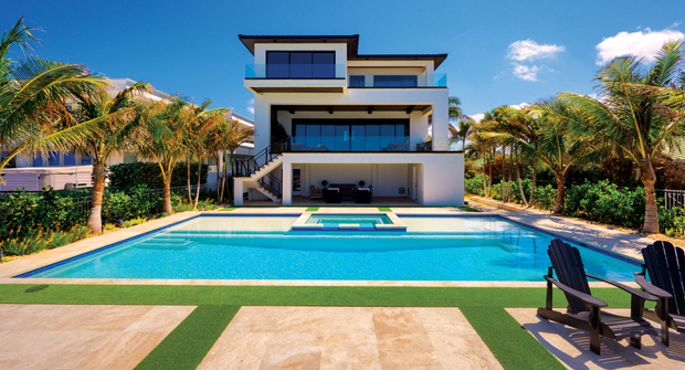 Given the tough environmental conditions, the backyard was fitted with custom travertine inserts and artificial turf near the pool to help with durability.(Photo: Landscapes by Randy Lee)