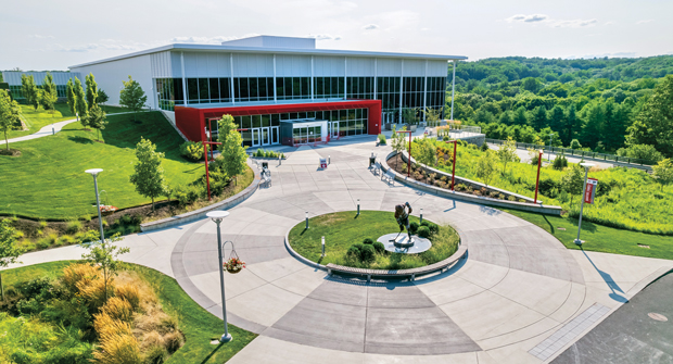 Martire Family Arena's main entrance features focal points, hanging baskets in school colors and a water-conserving landscape planted with bergamot and northeast native plant material, including low-grow blueberry bushes. (Photo: Eastern Land Management)