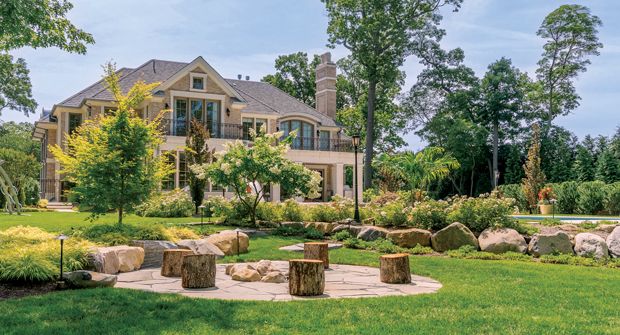 The family asked for a wood-burning fire pit, so Goldberg and Rodler installed one with a Long Island boulder retaining wall to sit on. Wooden logs from the trees they cut down also serve as extra seating.(Photo: Rachel Bires and Goldberg and Rodler, Inc.)
