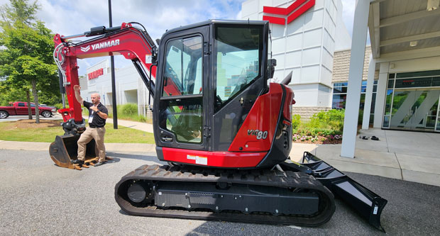 Yanmar product manager Zac Evans with the company's ViO80 mini excavator. (Photo: LM staff)