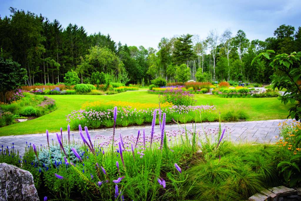 The goal of the project was to provide a serene lakeside retreat that could accommodate large family gatherings. Luxury features include elegant landscaping, an outdoor kitchen, a cozy fire pit area and more. (Photo: Sirna Productions and Patrick Hughes)