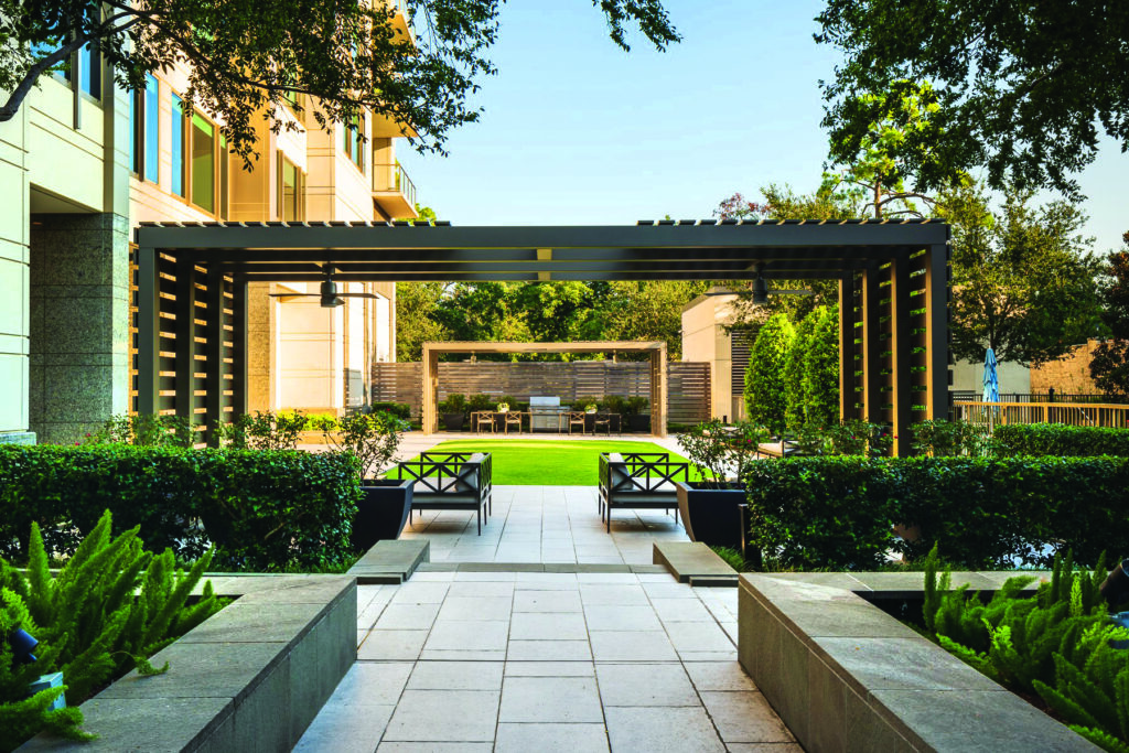 Foxtail fern and ligustrum hedges outline the entrance to the rear courtyard lawn. Cornell says the clients wanted artificial turf installations, grills and other backyard benefits to transform the site into a park-like space. (Photo: Monarch Landscape Management)