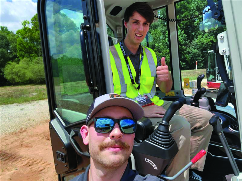 Smooth ride: Mader was busy “digging” into the story of Takeuchi’s new CTLs and excavators, but he stopped to snap a photo with Max Sinclair, who helped him not crash any of the machines. (Photo: LM staff)
