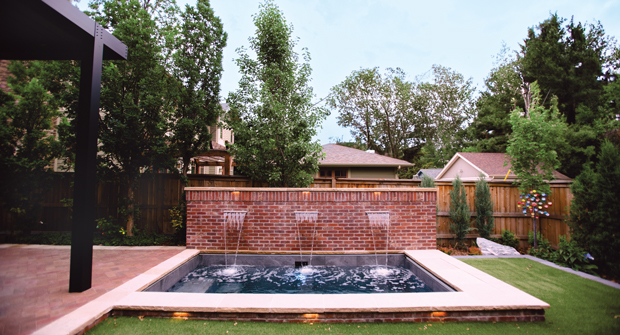 To get creative with saving space, Singing Hills used the area behind the Soake Pools plunge pool wall to hide utilities like landscape lighting transformers and a water pump for the pergola misters. (Photo: Singing Hills Landscape)