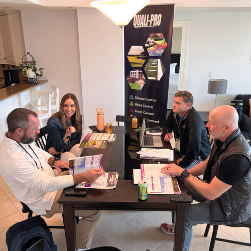 The team from Quali-Pro — Cal Hill (bottom right) 
and Chris Butcher — talk with Dan and Lisa Turner 
from Custom Lawns at the LM Growth Summit. (Photo: LM staff)