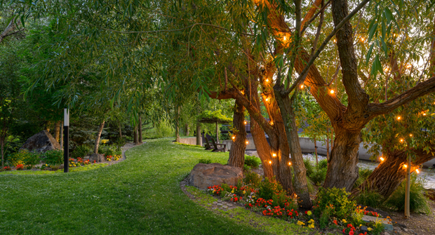 Trained trees provide natural shade, and personalized stone elements with the names of all of homeowners’ grandchildren offer thoughtful seating and reflect the family’s history.(Photo: Dave Koch at R\E Media Utah)